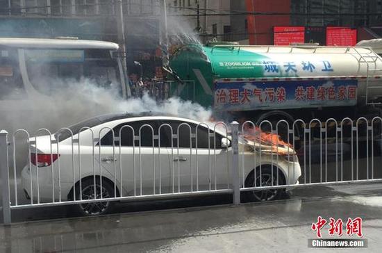 轿车闹市区自燃 过路洒水车边唱歌边灭火|洒