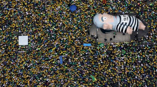 游行民众高举前总统卢拉的人形气球，他因发展经济得力受到巴西民众爱戴。卢拉因涉嫌受贿于3月4日被警方带走协助调查。（网页截图）
