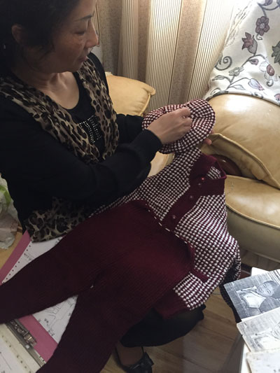 张雪霞展示当年给儿子织的枣红色毛线套装。
