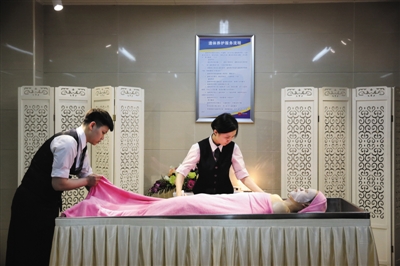  昨日，北京市八宝山殡仪馆首届公众开放日。殡仪服务人员正在通过模特演示遗体沐浴的过程。本版摄影/新京报记者 卢淑婵