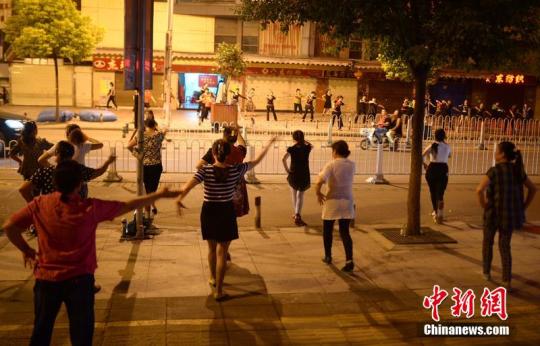 资料图：2015年10月，在湖北省武汉市汉正街小商品市场多福路上，数百名汉正街小商品市场的女老板们，在路边的空地上跳起了欢快的广场舞。图片来源：CFP视觉中国