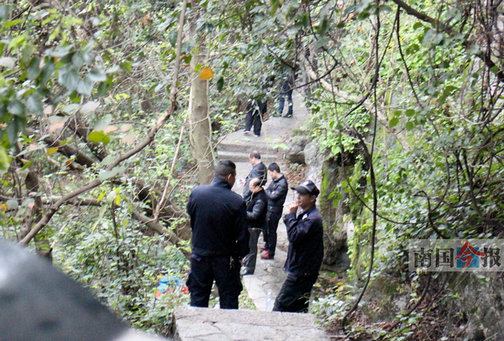 公安安保人员在女子坠山区域封锁现场勘查。