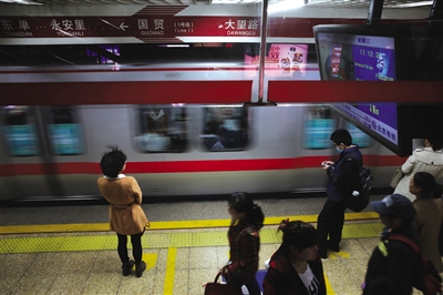 昨日，国贸地铁1号线，乘客们在站台候车，一辆列车驶入站台。