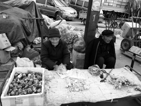 一位老妇人正在卖大蒜。包子铺此前免费的大蒜被要1头1元钱。