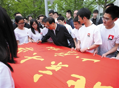 昨日，在考察北京大学时，李克强在北大山鹰社社旗上签名。