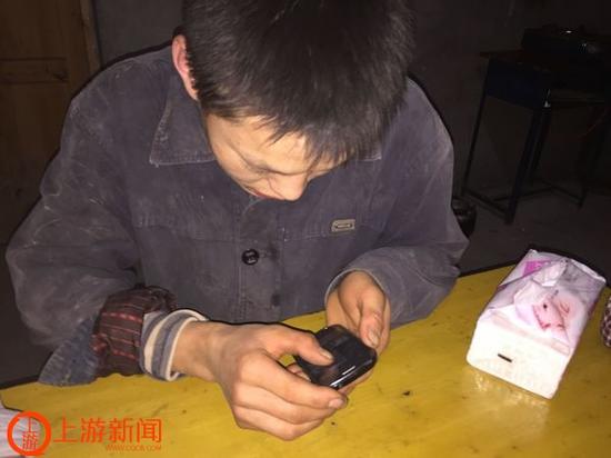 在滁州，工友们给他买了手机，在路上他最喜欢用手机听历史故事，如今他还学会了用手机玩微信。上游新闻记者 张曼双 摄
