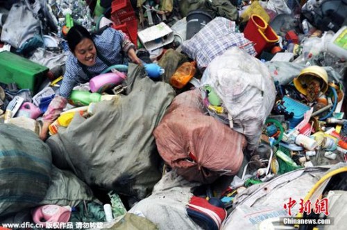 资料图。2015年4月6日，重庆，这是清理工在堆码场将大包的垃圾转运至分拣点，以方便开包处理。 江上鸥 摄 图片来源：东方IC