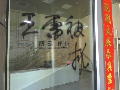 博瑞祥恒公司的玻璃门被人喷上王雷被抓的字样。京华时报记者 韩天博 摄