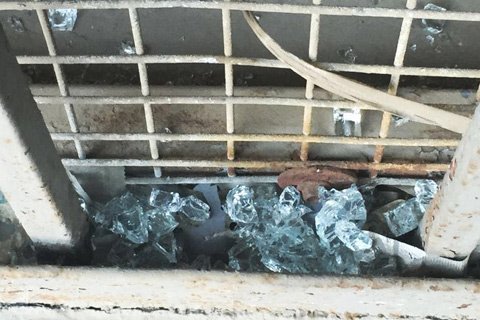 饭店马路对面地铁隔离网上，散落着许多被炸碎的饭店玻璃门碎屑。