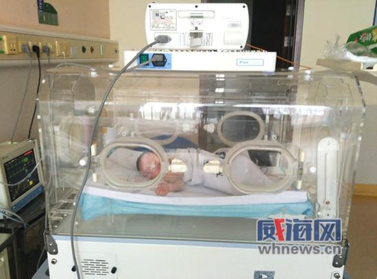 获救的男婴在医院的保温箱内熟睡。
