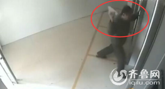 男子拿鞋子拍打取款机，随后男子出去又拿了一块板砖进来砸取款机。（视频截图）