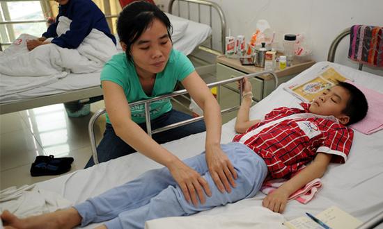 合川区合洲医院，刘峻成的妈妈正给他做按摩。重庆晨报—上游新闻记者 李斌 摄