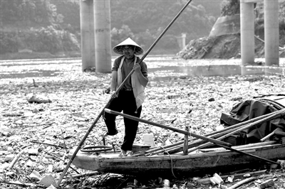 正在乐昌峡大坝上游库区清除垃圾的船工（4月13日摄）。记者 刘大伟 摄