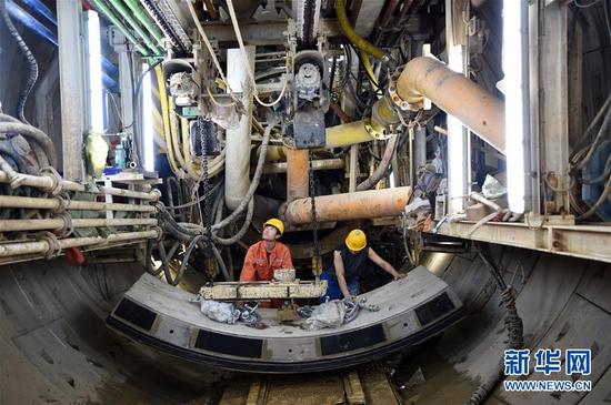 5月9日，在兰州中国铁建十四局集团“金城四号”盾构机内，施工人员调运盾构管片准备衬砌隧道。当日，在黄河兰州段地面以下40米深处，中国铁建十四局集团“金城四号”盾构机从黄河北岸中间风井缓缓破洞而出，我国首条“穿黄”地铁——兰州地铁隧道1号线右线顺利贯通。兰州轨道交通成功穿越黄河河床、大堤等重大风险源，为年底全线洞通奠定了基础。新华社记者 范培珅 摄