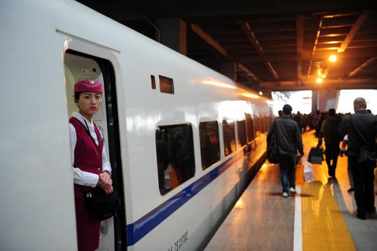 5月14日，在汉口火车站，一名乘务员等待旅客上车。新华社记者 冯大鹏 摄