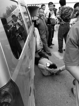 事故发生后，小伙躺在面包车车下■晨报拍客 张先生 供图