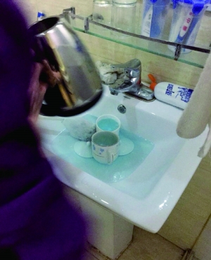 酒店服务员用洁厕液刷烧水壶和茶杯。