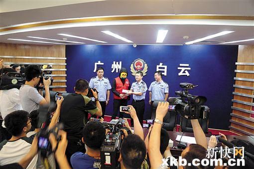 因举报涉毒案件线索而获奖的“快递小哥”戴着面具领取奖金。