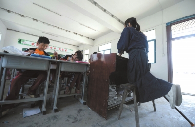 李元芳跪在板凳上讲课。本版图片京华时报记者陶冉摄