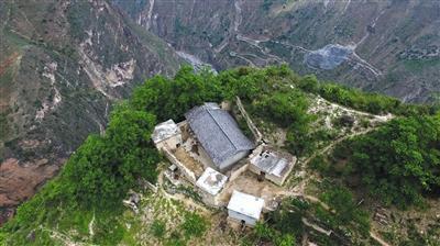 5月13日，无人机俯瞰位于悬崖边缘的村民某色拉则的家，他家的后院门推开就是悬崖，房屋所在位置也是全村最高点。