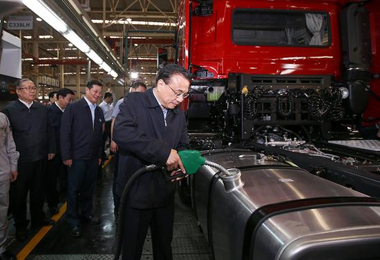 2016年5月23日，李总理到湖北十堰考察东风商用车重卡新工厂，在装配生产线旁应邀为新型重卡加油。（资料图）