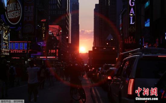 资料图：当地时间2014年7月11日，美国纽约曼哈顿再现“曼哈顿悬日”景观，引得路人纷纷围观。