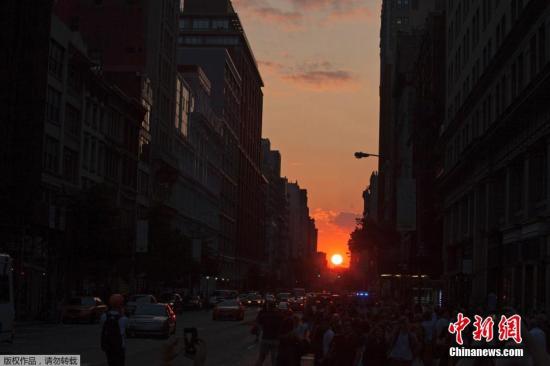 资料图：当地时间2014年7月11日，美国纽约曼哈顿再现“曼哈顿悬日”景观，引得路人纷纷围观。