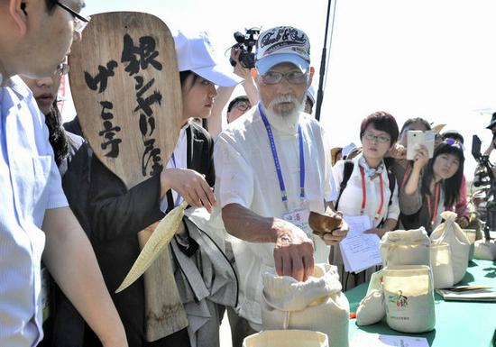 村嶋孟在盘锦选米。图片来自新华社。