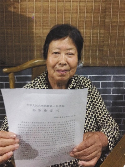 昨日，聂树斌母亲拿着最高法院的再审决定。受访者供图