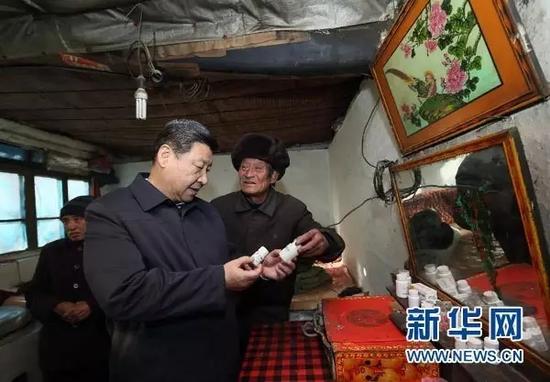 图为：2012年12月29日至30日，中共中央总书记、中央军委主席习近平在河北省阜平县看望慰问困难群众，考察扶贫工作。这是12月30日，习近平在龙泉关镇骆驼湾村困难群众唐荣斌家，详细询问身体有病的唐荣斌（右）日常服药情况。