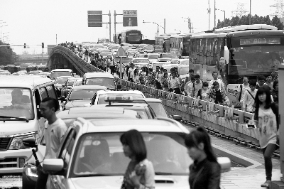 今天上午九时许，京通大望桥进京方向堵车严重，乘客下车步行   摄/记者  黑克