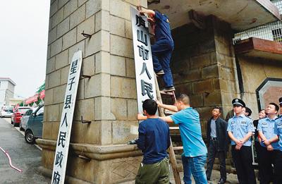 5月30日，江西省庐山市正式成立。图为工作人员悬挂庐山市人民政府的牌子。一旁是刚刚取下的星子县人民政府的牌子。新华社记者 周 密摄
