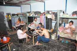 在太原和平公园工地的彩钢房里，来自陕西汉中的务工人员在一起打牌。这里住着8对夫妇，床铺用布帘遮挡形成相对私密的空间。