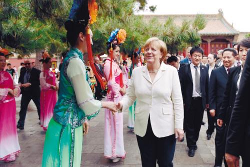 在沈阳故宫(微博)前，默克尔与穿着古装的“宫女”亲切握手，毫无违和感