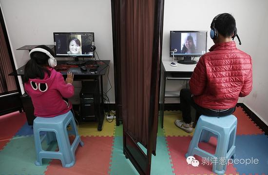2016年4月26日，朱昌镇小学，两名学生，正通过学校聊天室里的电脑和在外打工的妈妈视频聊天。