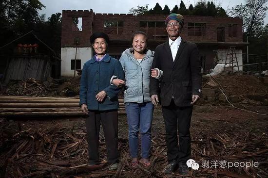2016年4月23日，毕节市田嵌彝族乡，张莉琴和爷爷奶奶，背后是她家正在盖的新房。她的父母在外打工。