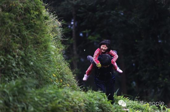 2016年4月25日，贵州毕节市纳雍县，居仁中学的王蕾老师，正背着女儿走在去家访的山路上。