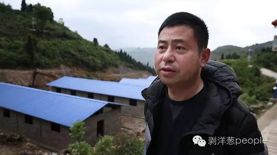 2016年4月23日，毕节市田嵌彝族乡第一书记梁曙，背后是他上任后帮助村里建立的母猪繁殖基地。