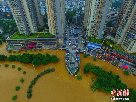 6月16日，因受暴雨影响，柳州呈现洪水围城的情景。图为航拍广西柳州市金沙角，船型建筑如在水中航行。 钟欣 摄