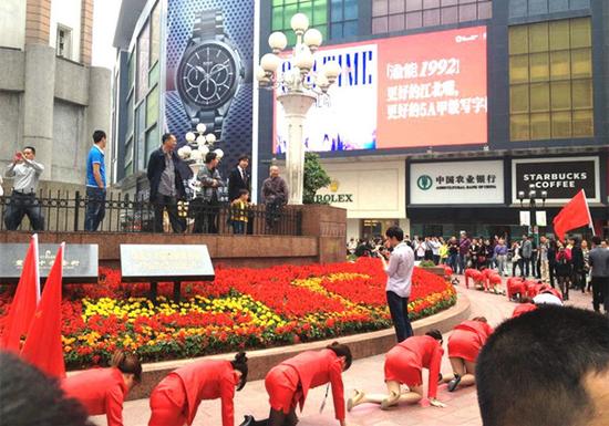重庆解放碑，一化妆品公司组织员工爬行
