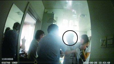  民警冲进房间时，犯罪嫌疑人(画圈处)正右手持刀，左手挟持女子
