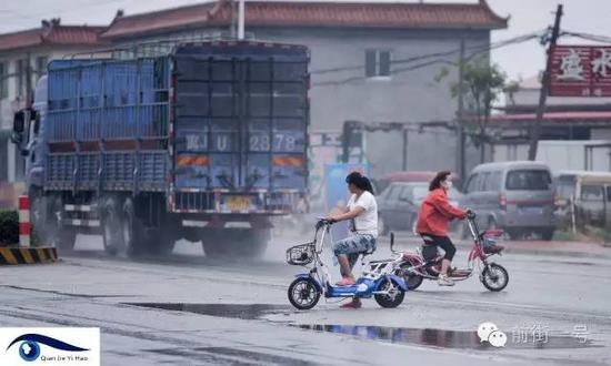 道路上大货车、电动车交错行驶。