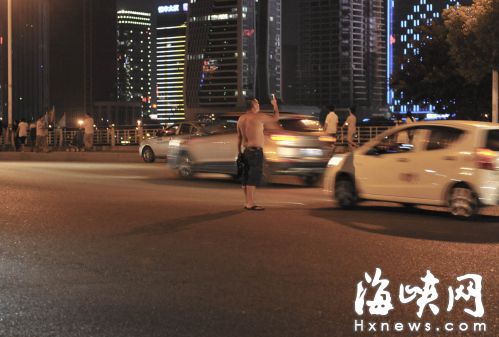 一名男子横穿马路还玩手机
