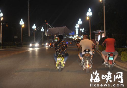南江滨西大道，几辆电动车并排骑在快车道上