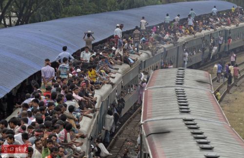 资料图片：当地时间2015年9月22日，孟加拉国达卡，穆斯林传统佳节“宰牲节”即将来临，人们纷纷乘上拥挤的火车赶回家欢度节日，场面颇为壮观，连火车顶部也是人山人海。