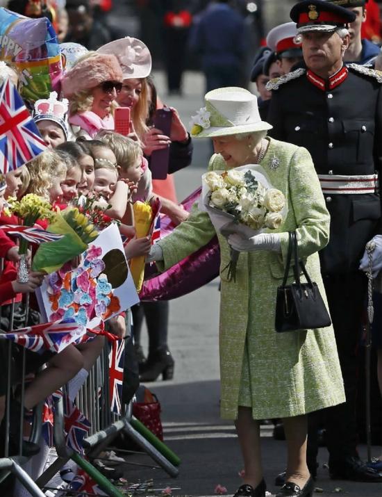 资料图：在英国伦敦以西的温莎堡外，英国女王伊丽莎白二世接受民众赠送的鲜花。