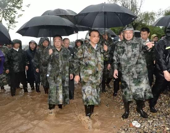 李克强总理趟水在青山倒口湖堤段管涌现场指挥抢险救灾。  长江日报记者周超 摄