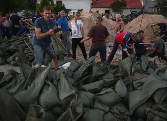 2013年德国遭遇洪水，群众用沙袋防洪。（图片来源：cfp）