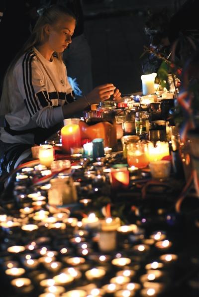 7月15日，一名女子在巴黎共和国广场点蜡烛，悼念尼斯袭击事件中的遇难者。据新华社
