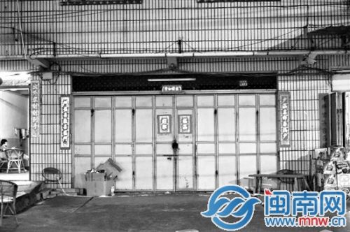 事发楼房大门紧闭，门前地上还散落着警戒条